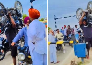 Viral: 100 किलो की बाइक कंधे पर यूं उठाकर पार की रेलवे क्रॉसिंग, शख्स का ‘बाहुबली’ अवतार देख हिल गए लोग!